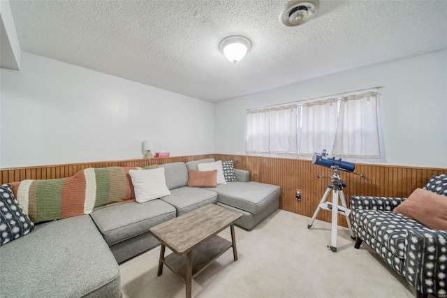 carpeted living room featuring a textured ceiling and wooden walls