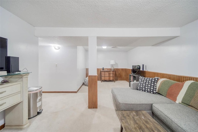 living room featuring light carpet, wood walls, and a textured ceiling