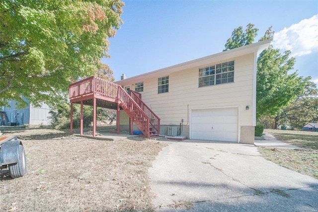 back of property featuring central AC, a wooden deck, and a garage