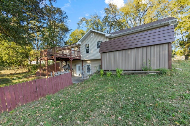 back of property featuring a deck and a yard