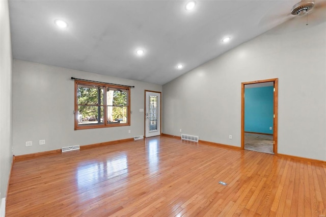 empty room with light hardwood / wood-style flooring and lofted ceiling