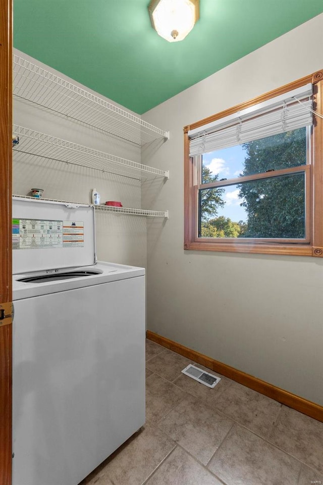 clothes washing area with light tile patterned floors and washer / clothes dryer