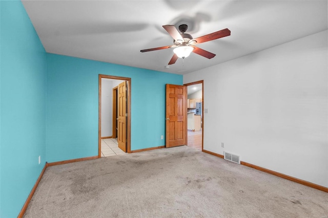 spare room with light colored carpet and ceiling fan