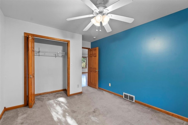 unfurnished bedroom with a closet, ceiling fan, and light carpet