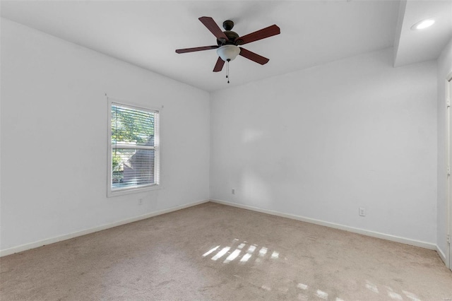 spare room with light colored carpet and ceiling fan