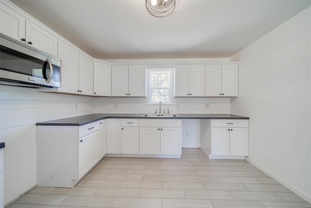 kitchen with backsplash, sink, and white cabinets