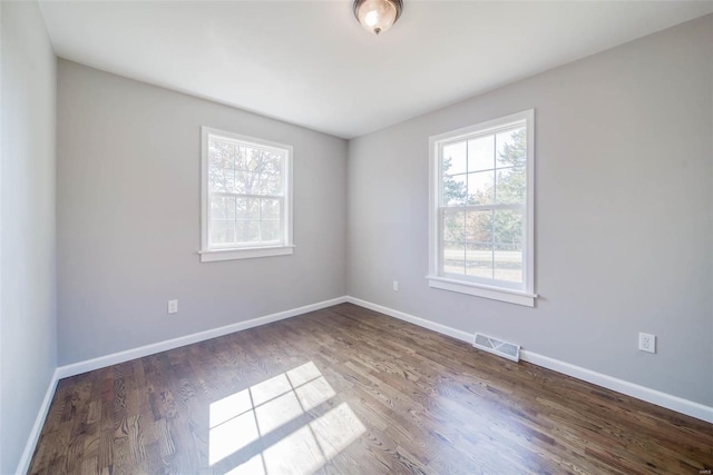 unfurnished room with dark wood-type flooring