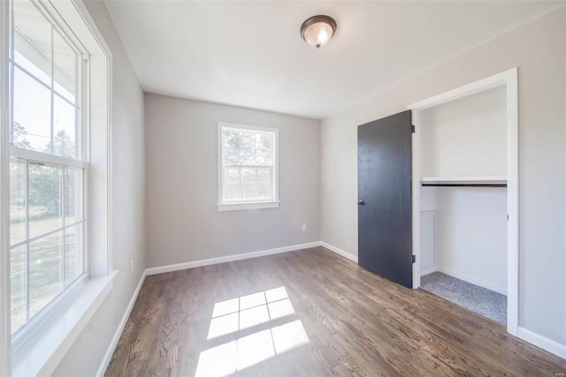 unfurnished bedroom featuring wood-type flooring and a closet