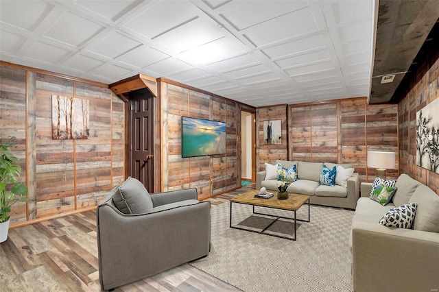 living room featuring hardwood / wood-style floors, wooden walls, and coffered ceiling