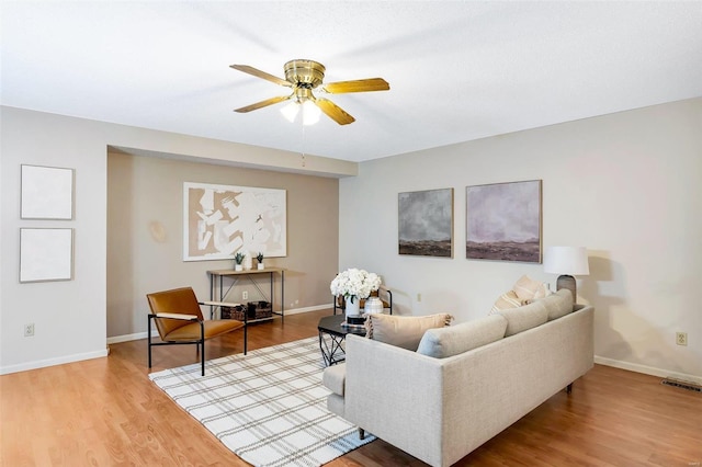 living room featuring wood-type flooring and ceiling fan