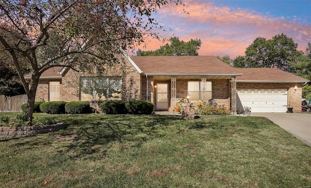 ranch-style house featuring a yard and a garage