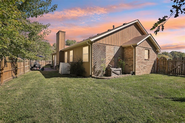 property exterior at dusk with a lawn