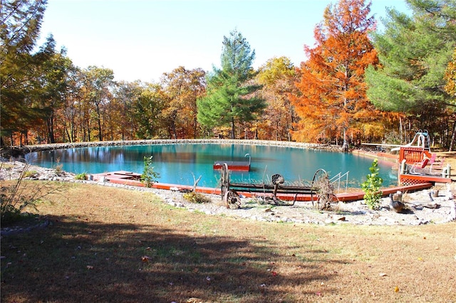 view of swimming pool featuring a water view and a boat dock