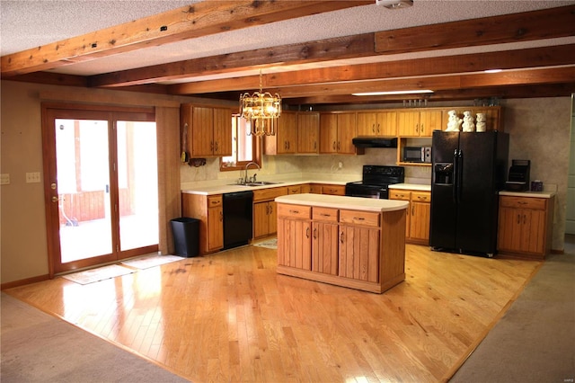 kitchen featuring beam ceiling, light hardwood / wood-style flooring, black appliances, sink, and decorative light fixtures