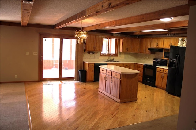 kitchen with black appliances, a center island, pendant lighting, and light hardwood / wood-style floors