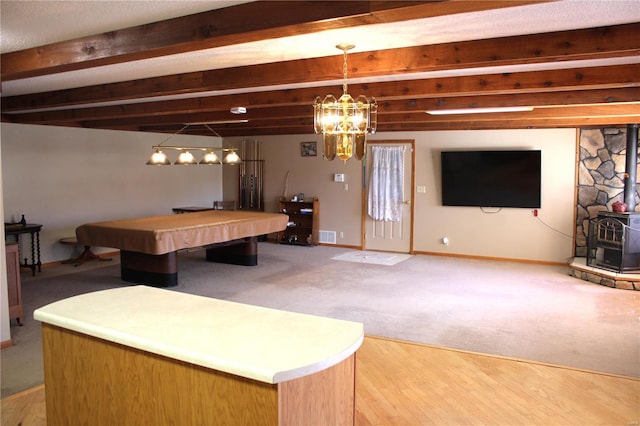 game room with beam ceiling, a wood stove, billiards, and hardwood / wood-style floors