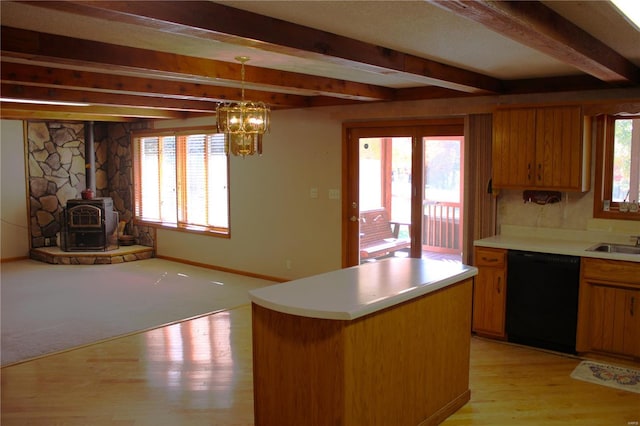 kitchen featuring a wood stove, black dishwasher, and a wealth of natural light