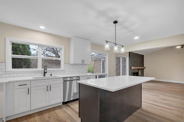 kitchen featuring white cabinetry, a healthy amount of sunlight, stainless steel dishwasher, and sink