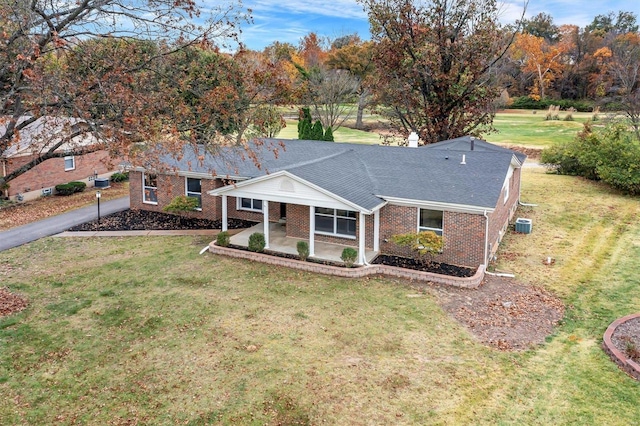 ranch-style house with a front yard and central AC