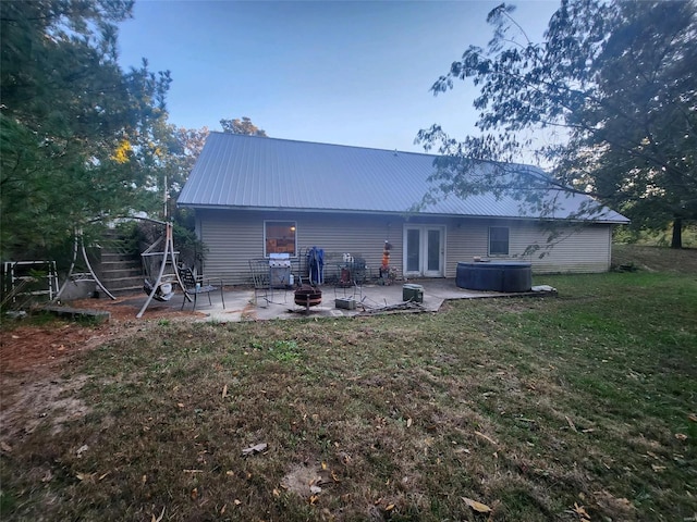 back of house featuring a patio, a lawn, and french doors