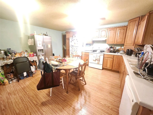 kitchen with electric stove, a textured ceiling, light hardwood / wood-style flooring, and stainless steel refrigerator with ice dispenser