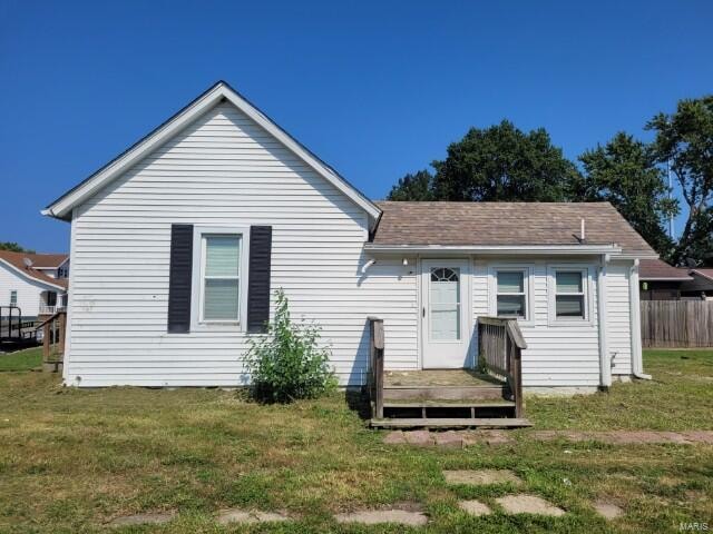 rear view of property with a yard