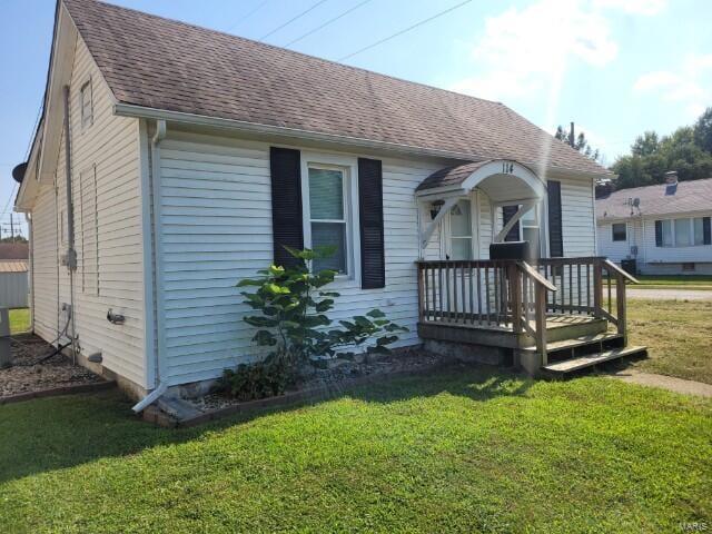 bungalow-style house featuring a front yard and a deck