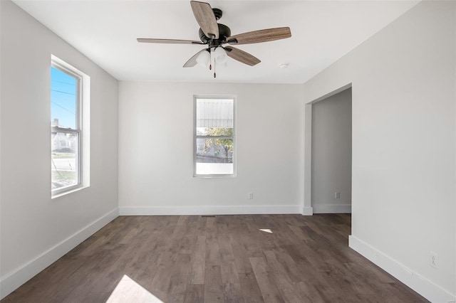 empty room with dark wood-type flooring, ceiling fan, and plenty of natural light