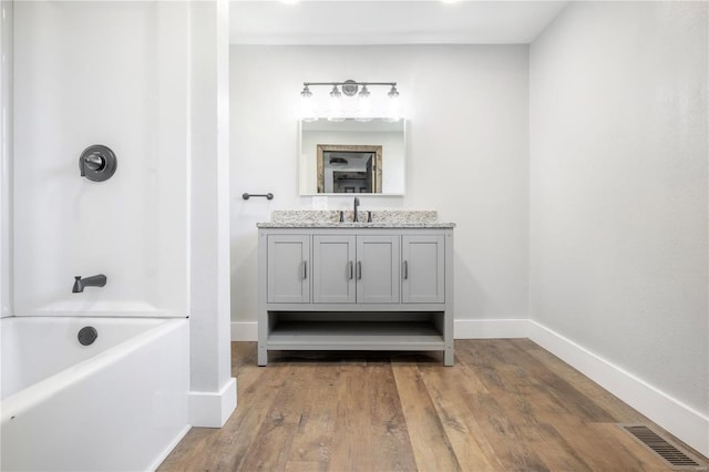 bathroom featuring vanity, hardwood / wood-style flooring, and plus walk in shower