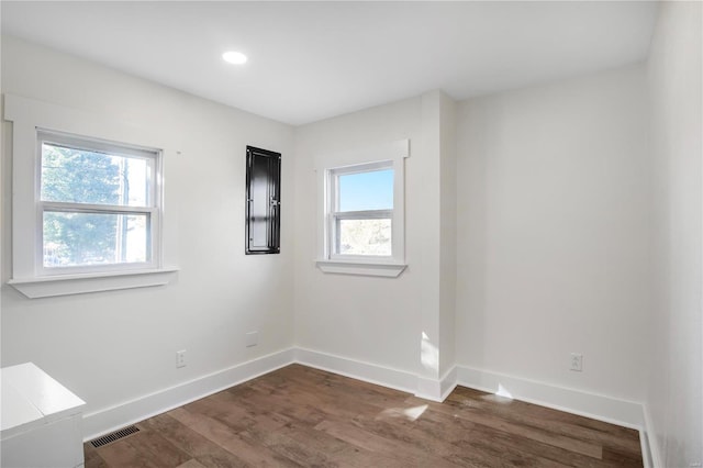 spare room featuring dark hardwood / wood-style floors and plenty of natural light