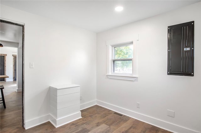 spare room with dark hardwood / wood-style floors and electric panel