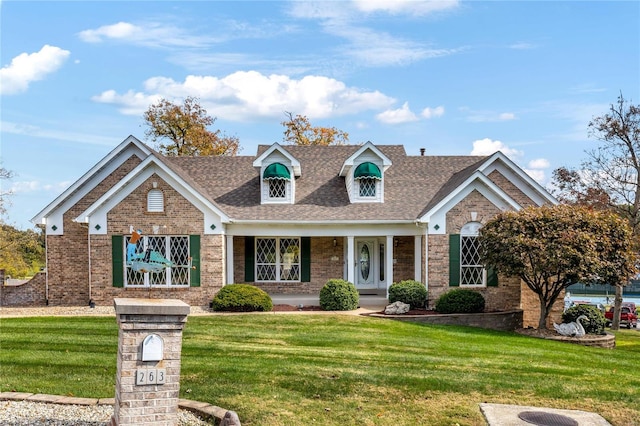 cape cod home with a front lawn