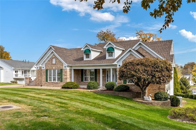 cape cod house featuring a garage and a front lawn