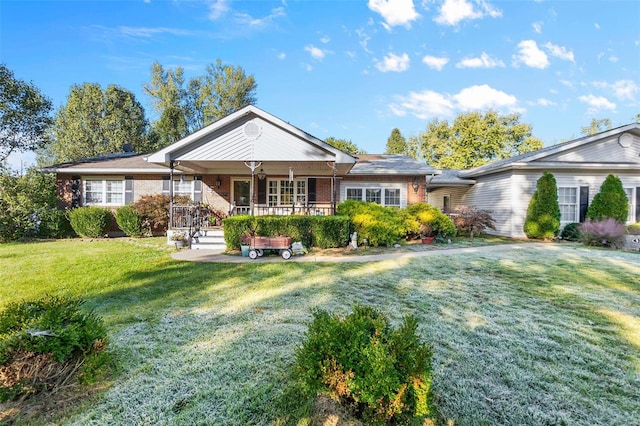 back of property with a yard and a porch