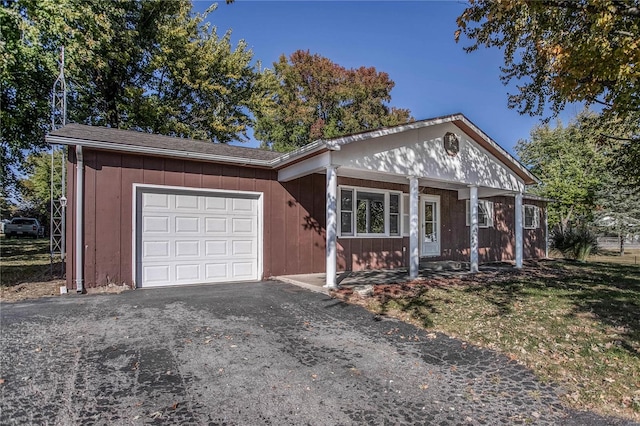 ranch-style home featuring covered porch and a garage