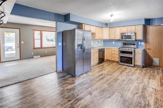 kitchen with light hardwood / wood-style floors, appliances with stainless steel finishes, a textured ceiling, and light brown cabinetry