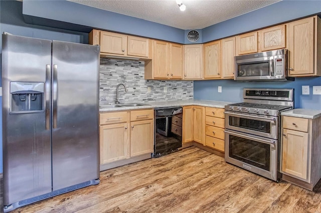 kitchen featuring appliances with stainless steel finishes, light hardwood / wood-style flooring, sink, and light brown cabinets