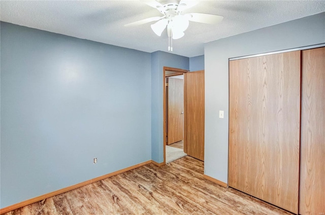 unfurnished bedroom featuring a closet, ceiling fan, a textured ceiling, and light wood-type flooring