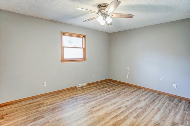 empty room featuring ceiling fan, a textured ceiling, and light wood-type flooring