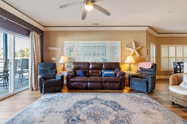 living room featuring crown molding, a healthy amount of sunlight, and wood-type flooring