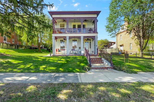 view of front facade with a front lawn, covered porch, and ceiling fan