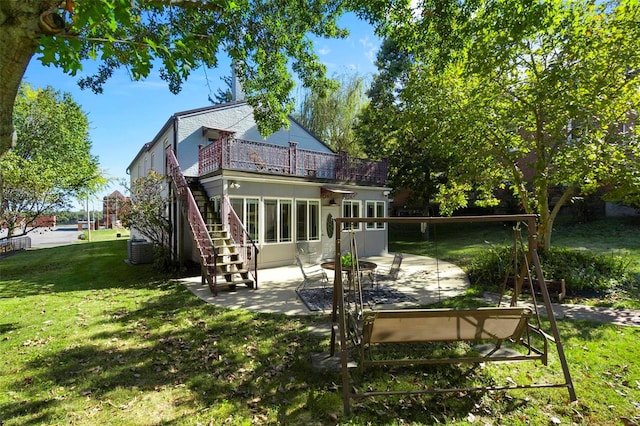 rear view of property featuring a yard, a patio area, and central air condition unit