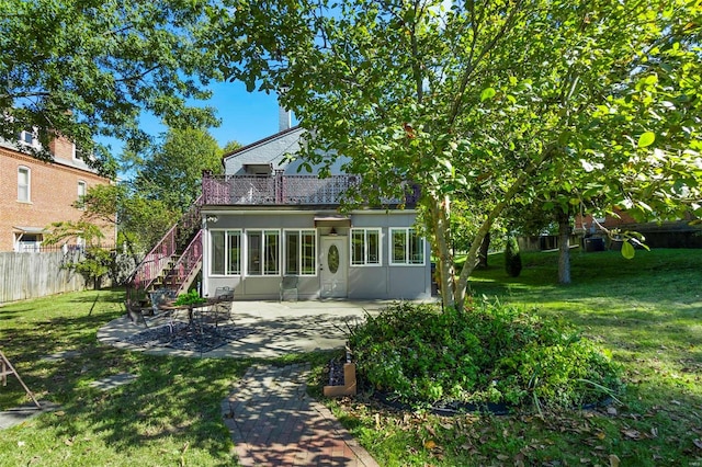 rear view of house featuring a patio and a yard