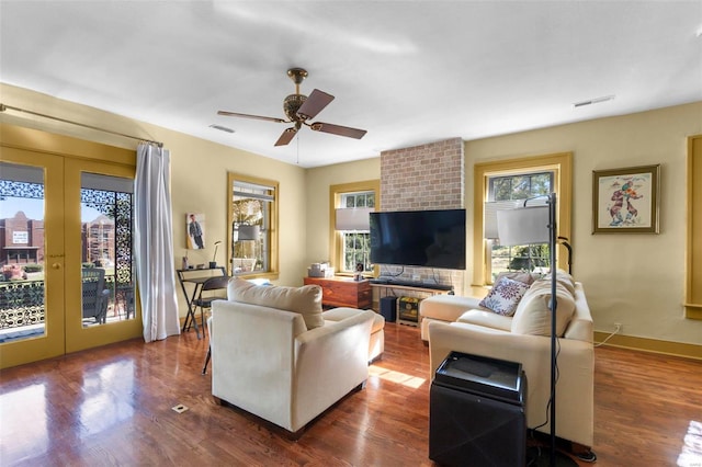 living room featuring a wealth of natural light, french doors, dark hardwood / wood-style floors, and ceiling fan