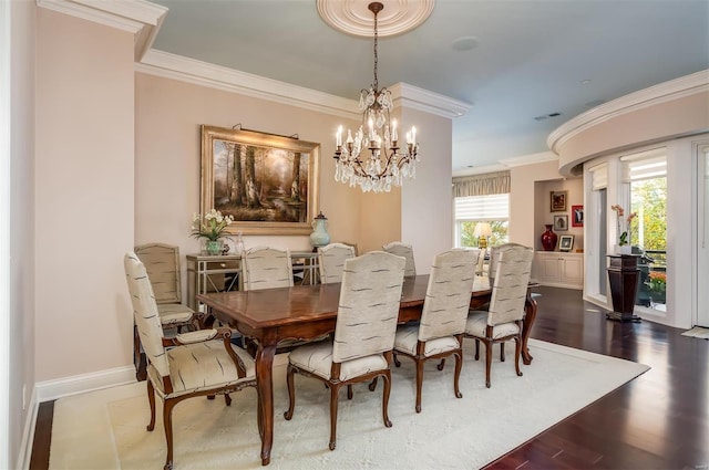 dining room with crown molding, hardwood / wood-style flooring, and a notable chandelier