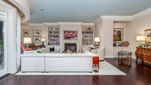 living room with ornamental molding, dark hardwood / wood-style floors, and built in shelves