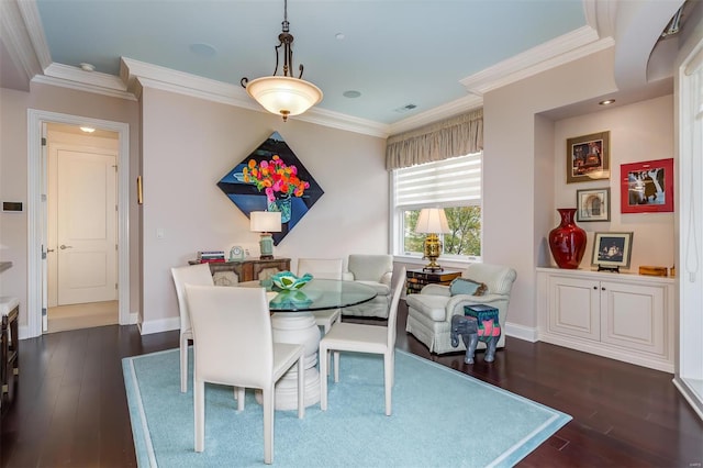 dining space featuring dark wood-type flooring and crown molding