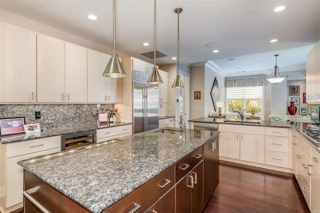 kitchen with dark stone counters, sink, crown molding, beverage cooler, and appliances with stainless steel finishes