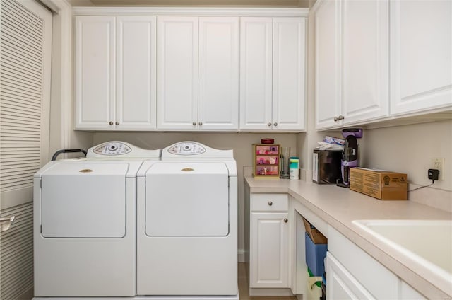 laundry room featuring cabinets, sink, and washer and clothes dryer