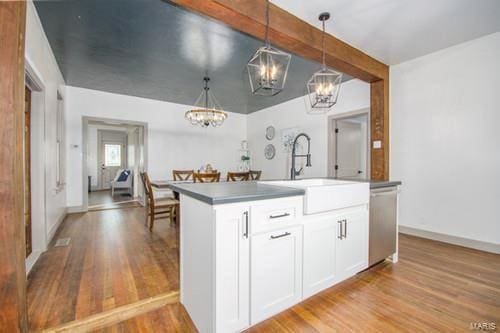 kitchen featuring sink, pendant lighting, stainless steel dishwasher, white cabinets, and light hardwood / wood-style floors